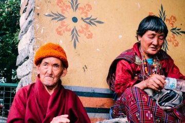 man in red robe bhutan tour package